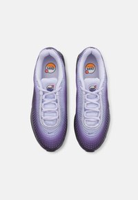 Lilla gradient idrettssko med mesh-overdel, hvite snører og polstrede krager. Har Nike-logo og teksturert gummisåle.