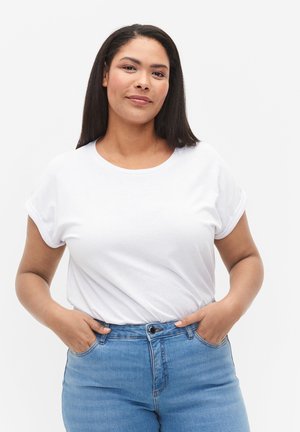 White short-sleeve t-shirt with a round neckline, paired with blue high-waisted jeans. Simple design with rolled sleeve accents.