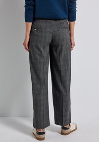 Pantalons à carreaux gris avec une coupe droite, dotés d'une taille et de poches arrière. Le tissu a une finition texturée, complétée par des coutures visibles.
