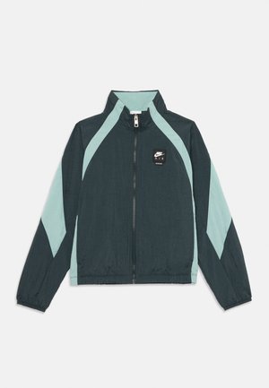 Mørkegrøn og lysegrøn Nike Air zip-up træningsjakke med høj krave og lange ærmer, med logopatch på brystet.