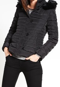 Černá péřová bunda s kapucí, která má umělou kožešinovou obrubu, horizontální prošívání a zapínání na knoflíky vpředu se zipovými kapsami.