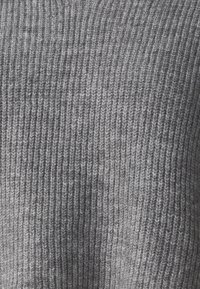 Szary dziany materiał z pionowym teksturem prążkowanym. Miękka, średniej grubości mieszanka wełny z różnymi odcieniami szarości, tworzącymi głębię.