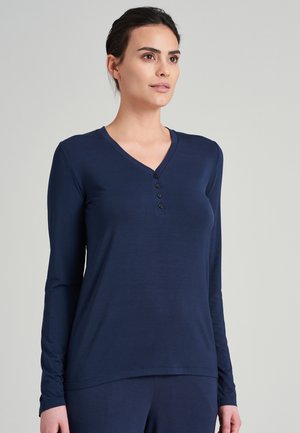 Marinblå långärmad topp i ett mjukt tyg, med en V-ringning och fem små svarta knappar framtill. Enkelt och figurnära design.
