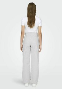 Witte T-shirt met korte mouwen, gecombineerd met high-waisted, wijde grijs-witte gestreepte broek. Voorzien van zijzakken. Glad textuur.