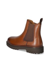 Brun läderankelboot med elastiska paneler, rund tå och en tjock, räfflad sula. Har en dragflik baktill för att enkelt kunna ta på sig dem.