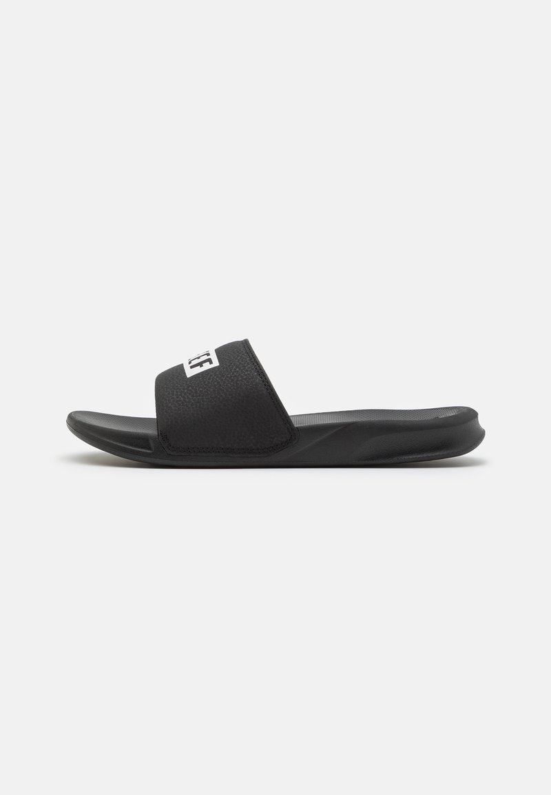 Sandálias de slide pretas com um superior texturizado e uma sola de borracha lisa. Apresentam uma faixa larga e um detalhe de logotipo na parte frontal.
