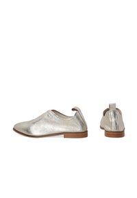 Metallisch silberne flache Schuhe mit glatter Textur, rundem Zehenbereich und niedriger brauner Ferse. Mit einer Zuglasche an der Rückseite für ein einfaches Anziehen.