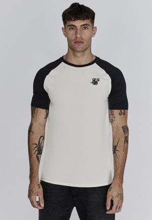 White and black raglan t-shirt with short sleeves, featuring a black logo on the chest and a smooth cotton texture.