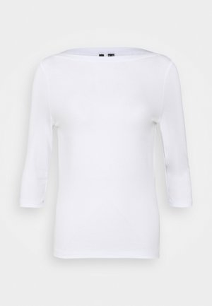 Chemise blanche ajustée à manches longues trois-quarts avec un large col bateau sur un fond uni.