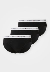 Schwarzes Baumwollunterwäsche-Set mit drei Teilen, ausgestattet mit einem weißen Bündchen mit "TOMMY HILFIGER"-Logo und einem glatten, eng anliegendem Design.