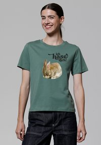 Grünes Baumwoll-T-Shirt mit einer Grafik eines schlafenden Kaninchens und dem Text "ich hasse dich!" in fetter schwarzer Schrift. Kurze Ärmel und runder Halsausschnitt.