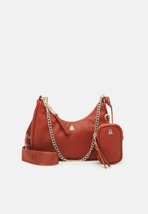 Skuldertaske i rustfarvet læder med gyldenkæde og stofrem med mærke, med en lille matchende pung fastgjort med lynlås.