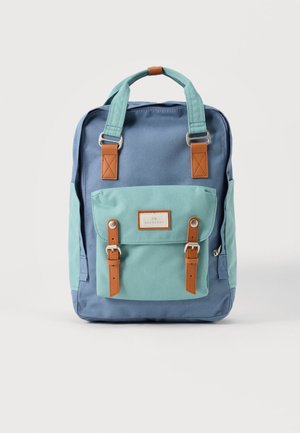 Μπλε και τιρκουάζ σακίδιο πλάτης με τιρκουάζ λαβές, καφέ λουριά με πόρπες, μπροστινή τσέπη και μια μικρή ορθογώνια ετικέτα στη μπροστινή τσέπη.