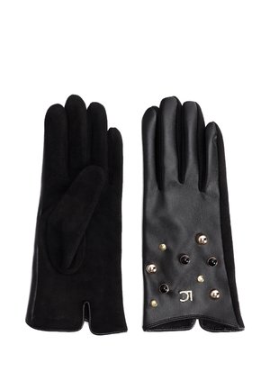 Paire de gants noirs, un en daim et un en cuir avec des clous noirs et dorés et un petit logo argenté au poignet.