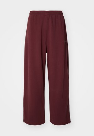 Tumedad laiad dressipüksid elastse vöökohaga, valmistatud pehmest kangast, millel on sile tekstuur ja puuduvad nähtavad mustrid või aktsendid.