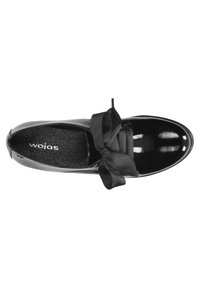 Scarpa in pelle verniciata nera con punta arrotondata, caratterizzata da un ampio fiocco in satin nero sulla tomaia e una soletta testurizzata con marchio.