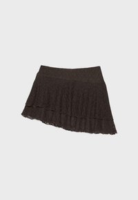 Jupe asymétrique en dentelle noire avec un design en couches et une large ceinture, présentée à plat sur un fond gris clair.