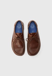 Brown leather shoes with a textured surface, round toe, and lace-up design. Inside features a blue insole with perforations for breathability.