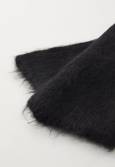 Tessuto nero e peloso con una superficie morbida e texture. Il materiale è leggero e leggermente traslucido, con fibre delicate e sciolte.