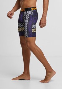 Čierne a fialové boxerky vyrobené z elastického materiálu, s vzorom reťazí a akcentmi. Elastický pás s logom.