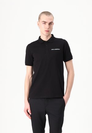 Polo nero con colletto classico, maniche corte e un piccolo logo bianco sul petto. Realizzato in tessuto liscio con una vestibilità regolare.