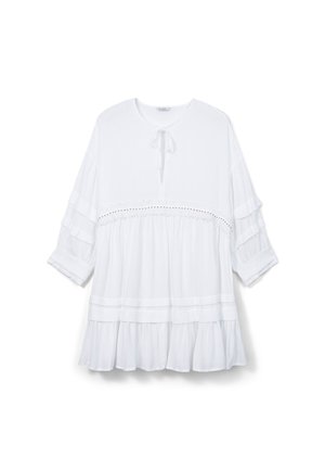Blouse légère et blanche avec une coupe décontractée, présentant un col rond, un détail à nouer, des manches froncées et un ourlet à volants superposés avec une finition en dentelle.