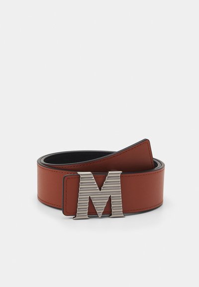 Brun lærbelte med svart bakgrunn, med en sølvfarget metallspenne formet som bokstaven "M" med ribbet detaljering.