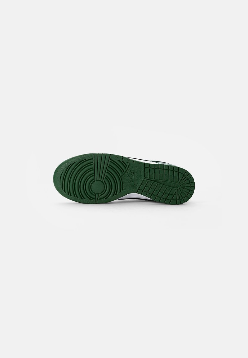 Suela de zapato de goma verde con patrones circulares y de rejilla, que presenta una superficie texturizada y bordes reforzados, mostrando durabilidad y tracción.