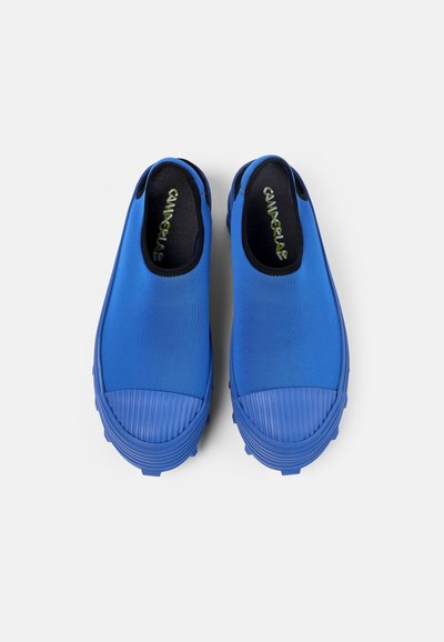 Blå slip-on skor med en slät ovandel, ribbad gummitåhätta och texturerad sula för bra grepp. Inre foder i svart med logotypdetalj.