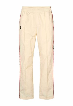 Světlé béžové sportovní kalhoty s šňůrkou v pase, červenými pruhy po stranách a vyšívanými logy na obou nohavicích. Hladká, lehká tkanina.