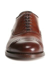Chaussure habillée en cuir marron avec un bout arrondi, un laçage droit et des perforations décoratives le long de la couture. Texture lisse et finition polie.