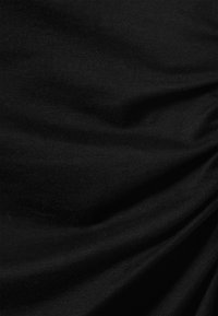 Schwarzer Stoff mit einer weichen Textur, der geraffte Details aufweist, die subtile Falten und Fältchen auf der Oberfläche erzeugen.