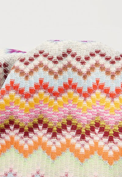 Χρωματιστό πλεκτό ύφασμα με γεωμετρικά σχέδια σε αποχρώσεις του λευκού, κόκκινου, πορτοκαλί, κίτρινου, ροζ, πράσινου και μπλε, διπλωμένο με ορατή υφή.