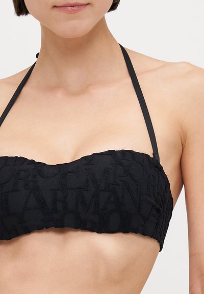 Black bandeau bikini top with textured fabric featuring embossed letters. Removable straps and gathered edges create a fitted design.