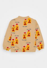 Camicia beige a maniche lunghe con grafiche di galline colorate e testo "EARLY BIRD", con polsini elasticizzati e una consistenza morbida.