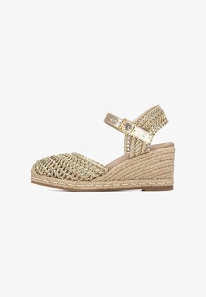 Sandalo espadrille con zeppa, suola in juta intrecciata, tomaia dorata intrecciata e cinturino alla caviglia con fibbia su sfondo bianco.