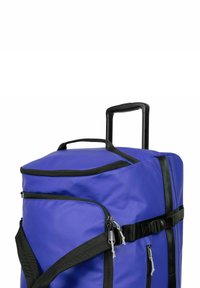 Große lila Duffelbag mit schwarzen Akzenten, stabilen Griff, Reißverschlussverschlüssen und verstellbarem Gurt für sicheres Tragen.