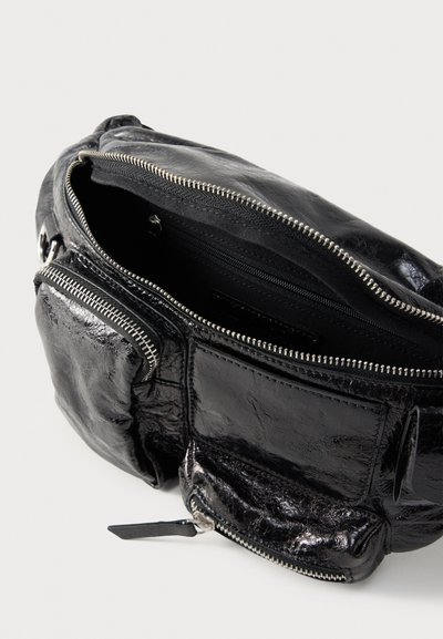 Μαύρη γυαλιστερή δερμάτινη τσάντα μέσης με τρεις θήκες με φερμουάρ, ανοικτή για να αποκαλύψει τον ευρύχωρο εσωτερικό χώρο της κύριας θήκης.