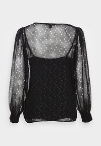 Schwarze Bluse mit einem durchsichtigen, gepunkteten Überzug, langen Puffärmeln und geknöpften Manschetten. Sie verfügt über kreisförmige Muster und einen quadratischen Ausschnitt.