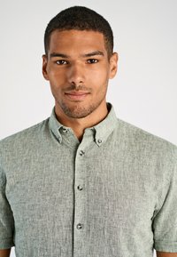 Korte mouwen button-up shirt in luchtige lichtgroene stof met een kraag, voorzien van zilveren knopen en een ontspannen pasvorm.