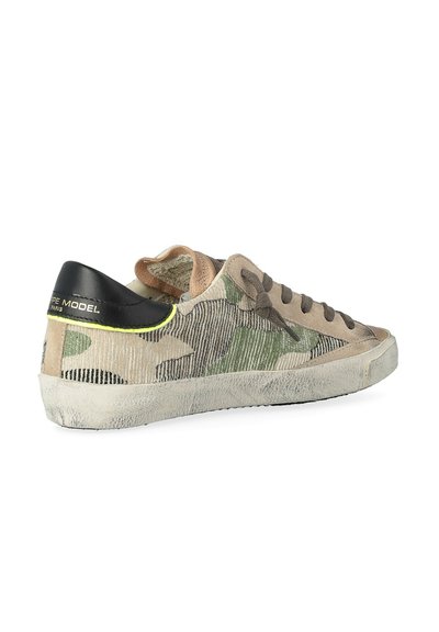 Baskets au motif camouflage vert et beige, avec un talon en cuir noir, un tissu texturé, un bout arrondi et des lacets marron.