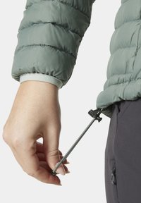 Zelená péřová bunda s texturovaným povrchem, se stahovací šňůrkou s černým zarážkou na lemu a manžetou s měkkou vnitřní podšívkou.