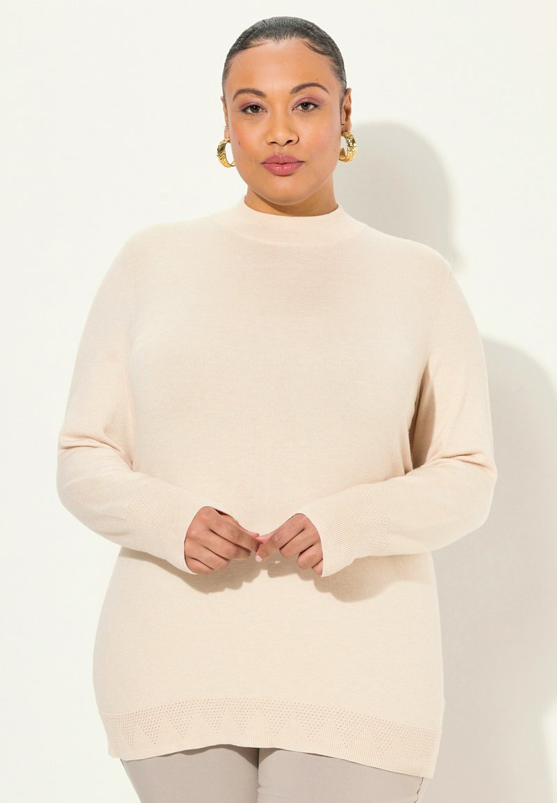 Maglione beige a maniche lunghe con collo alto, polsini a coste e un orlo testurizzato con un delicato motivo a triangolo. Tessuto in maglia morbida.