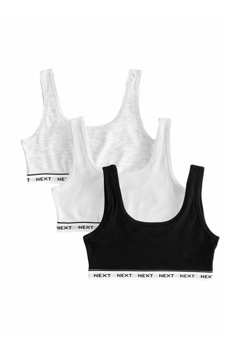 Tre top a girocollo: uno grigio, uno bianco e uno nero. Tutti hanno spalline spesse e bande elastiche con il logo "NEXT" in bianco sul fondo.