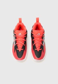 Ein Paar rote und schwarze Sport Sneakers mit weißen Sohlen und Schnürsenkeln, von oben auf einem schlichten weißen Hintergrund betrachtet.