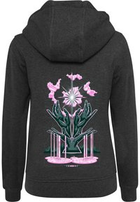 Sötét szürke kapucnis jumper, élénk zöld kezekkel és rózsaszín absztrakt formákkal, középen csillagformájú mintával.