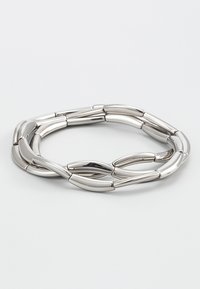 Sølvfarvet metalarmbånd med sammenlåsende aflange led, der har en glat, poleret overflade, hvilket skaber et flydende, moderne design.