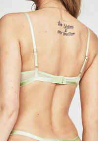 Jasnozielony biustonosz typu bralette z regulowanymi ramiączkami, wykonany z miękkiej siateczki i satyny, z zapięciem na haczyk i minimalstycznym designem.