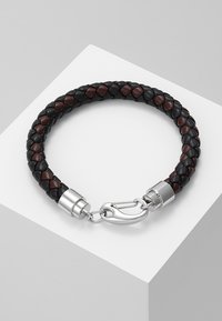 Brăță din piele împletită, de culoare neagră și maro închis, cu un închizător din metal argintiu și accente metalice fine. Finisaj texturat și formă solidă.
