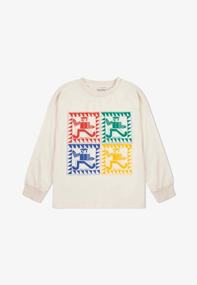 Helle beige Langarmshirt mit vier bunten grafischen Quadraten, die stilisierte Hundefiguren in Rot, Grün, Blau und Gelb zeigen. Weiche Textur.